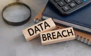 Two wooden blocks that read the words data breach sitting on a desk